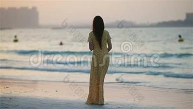 可爱的快乐小女孩在白色海滩日落。