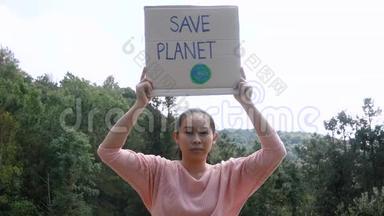这位年轻女子手持`拯救地球`<strong>海报</strong>，<strong>展</strong>示了抗议森林中塑料污染的标志。 的概念