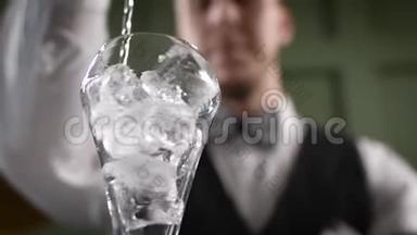 酒保把杯子<strong>凉了</strong>。 一个男人在鸡尾酒杯里干扰冰块。
