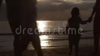 亚洲家庭幸福的剪影，晚上和日落一起在海滩上跑步放松