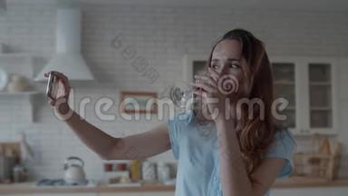 年轻女子摆姿势，拿着一杯红酒拍照。 女孩拍自拍照片。