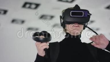 一名成年女子戴着虚拟现实眼镜，手持一个控制器，并在空中使用它作为视频游戏