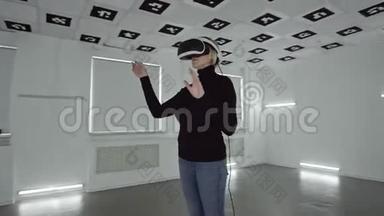 年轻女子戴着<strong>ps</strong> vr耳机，在一个充满白色霓虹灯的空房间里做手势。 跟踪弧