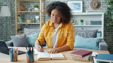 非洲裔美国青少年在家学习，在书桌前写读书