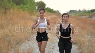 慢动作运动员女人和朋友一起跑步。 亚洲女跑运动员夏季耐力训练。 我知道