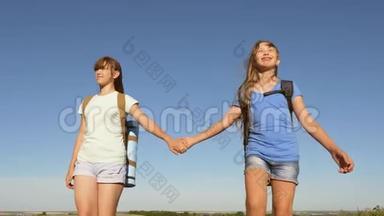 概念旅游和旅游.. 女孩们，女游客牵着手走在蓝天的背景上。 团队合作游客