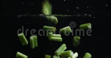 芹菜碎片<strong>落入水中</strong>，溅起水花和气泡。