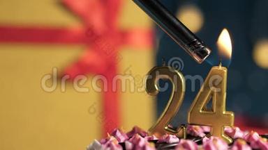 生日蛋糕24号金色蜡烛用打火机点燃，蓝色背景礼品黄色盒子用红丝带系好