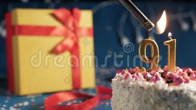 白色生日蛋糕编号91金色蜡烛用打火机燃烧，蓝色背景灯和礼品黄色盒子用<strong>红色系</strong>起来