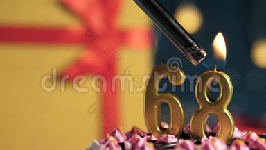 生日蛋糕数字68金蜡烛用打火机点燃，蓝色背景礼品黄色盒子用红丝带绑好