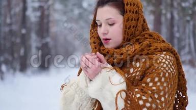 一位在户外散步的年轻女子在冬天的公园里呼吸以保暖的肖像。 慢慢