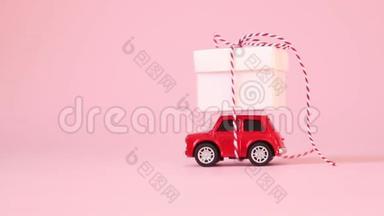 红色玩具车送货<strong>礼盒</strong>，带丝带蝴蝶结在粉红色背景上。 生日，<strong>情人节</strong>`，妇女节`概念..