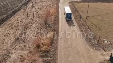 一辆<strong>大型卡车</strong>和一辆拖车沿着土路行驶，在附近寻找掉头的地方