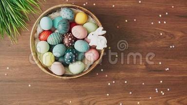 双手在装饰好的木桌上放下满是彩色复活节彩蛋和郁金香的巢。 复活节节日装饰品，复活节