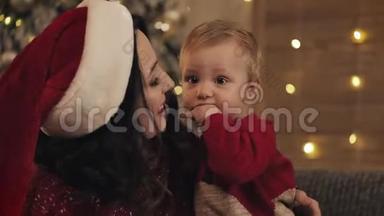 亲近微笑的白种人，妈妈，圣诞老人，亲吻她可爱的、快乐的孩子，家庭假日的概念