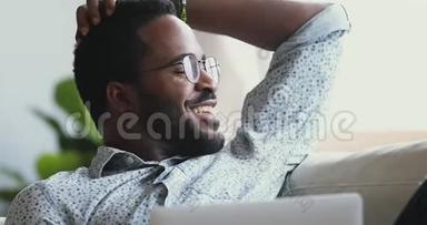 快乐满意的非洲男人放松笔记本电脑<strong>远离</strong>梦想