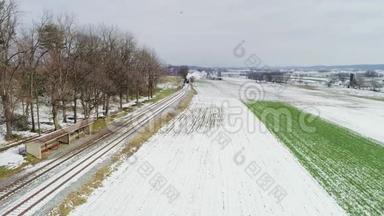 一场雪后沿阿米什农场土地的蒸汽机和乘用车的鸟瞰图