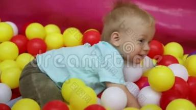 小男孩在游泳池里，在儿童娱乐中心`带球。 慢动作