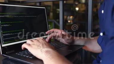 背视图肩上拍摄的开发人员与笔记本电脑程序员。屏幕上的程序代码和脚本数据。年轻的