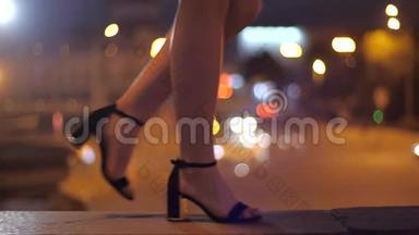 女孩走在公路上的城市桥上，穿着漂亮的高跟鞋，腿上有高跟鞋特写。 在傍晚的城市漫步
