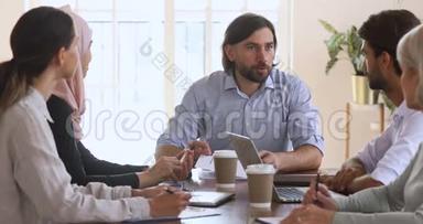 自信的男首席执行官领导<strong>公司员工</strong>会议坐在餐桌旁
