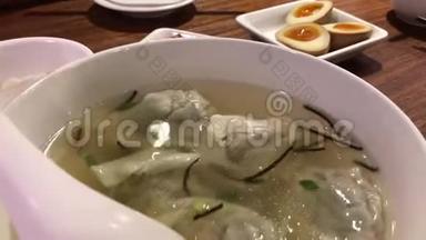 中餐厅桌上人们吃饺子汤和开胃菜的动作