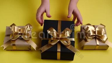 儿童`的双手将礼品盒贴在黄色背景上。 圣诞节，新年，生日概念。
