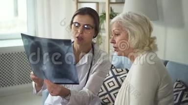 年轻的医生和成熟的老妇人手里拿着x光