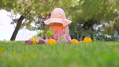 天然水果背景。 孩子在户外吃有机水果。 幼儿在阳光明媚的草地上玩新鲜水果