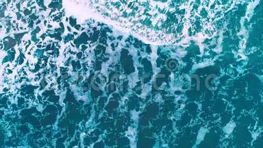 海浪溅到海滩上，鸟瞰。蓝色海水背景