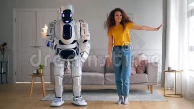 漂亮的女士和机器人在客厅里跳舞。 智能家居概念。