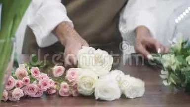 年轻迷人的女花店商人在他的花店里做一束花出售。 人民