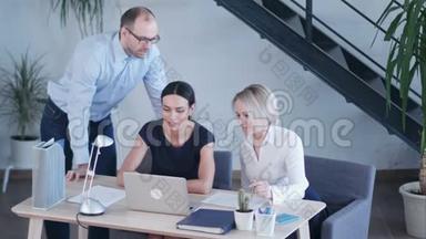 <strong>创业团队</strong>在现代明亮的办公室内部集思广益，工作在笔记本电脑上