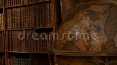 古老的大型古董地球仪。 美丽的老式旧书架和无名的书。 奥地利内政