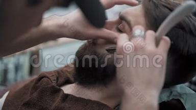 理发师在<strong>理发店</strong>或<strong>理发店</strong>用直刃剃须刀刮胡子。 男人`理发和刮胡子