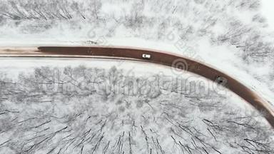 路面，顶部向下：汽车通过一个滑雪覆盖的交叉口。 在结冰的路面上驾驶的汽车上方飞行