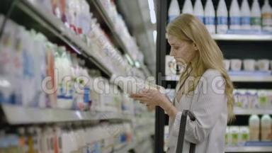 <strong>广告</strong>，商业，食品，健康概念-在<strong>超市</strong>里站在冰箱前的女人选择购买