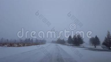 白天在农村公路上驾驶冬季暴风雪。 司机视角POV雪化暴雪乡村