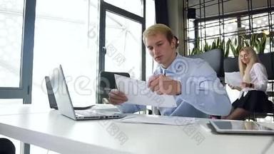 英俊的年轻金发商人漂亮的肖像，用笔记本电脑上的图表<strong>分析报告</strong>