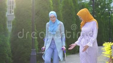 带着微笑的年轻女子在受伤后拄着拐杖，与女友在公园散步