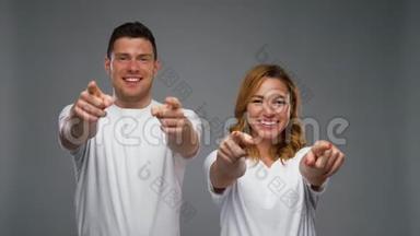 一对穿着白色t<strong>恤衫</strong>的夫妇在灰色的上空打手势