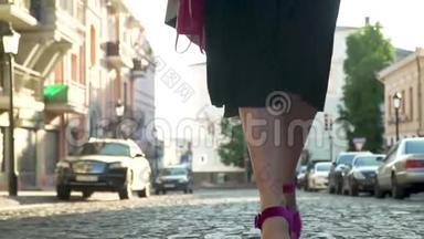 穿着黑色衣服，穿着紫色鞋子的女人穿着高跟鞋慢动作走路