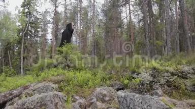 穿着黑色衣服的人独自走在一片深岩石林中。 旅行，健康的积极生活方式，冒险，户外