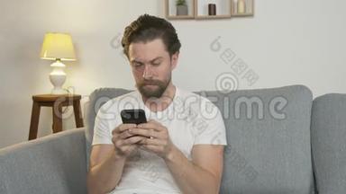 一个年轻人独自坐在家里的沙发上，与网上的人交流，孤立地阅读新闻