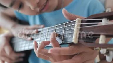 一位母亲近距离地教女儿如何演奏古典吉他，家庭活动为自学c