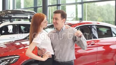 漂亮的一对夫妇拿着他们新车的钥匙，看着相机，微笑着