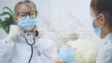 两个<strong>小女孩</strong>和白色泰迪熊坐在沙发上戴着医疗面具。 <strong>医生</strong>正在检查泰迪