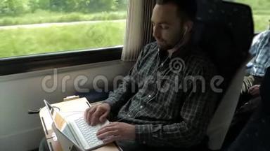 年轻的专家带着耳机在火车上用笔记本电脑通过视频聊天与雇主交谈。