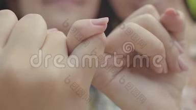 特写女生双手相握`小手指微笑着，在镜头前。 简洁的手势