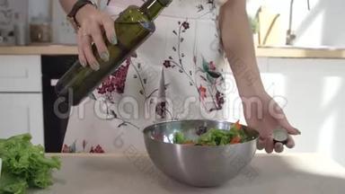 女人的手把橄榄油倒入玻璃碗里，配上新鲜的春天沙拉。 把做饭的女人的手收起来。 健康生活方式